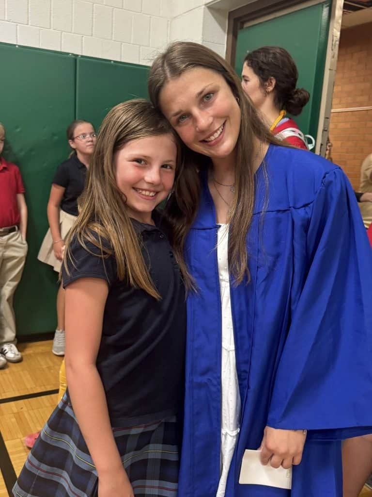 Happy student and teacher celebrating graduation at JFK Catholic School.