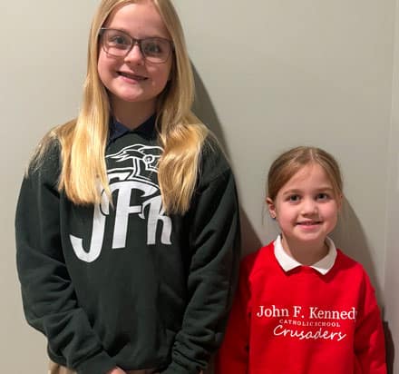 Two students wearing JFK spirit wear shirts.