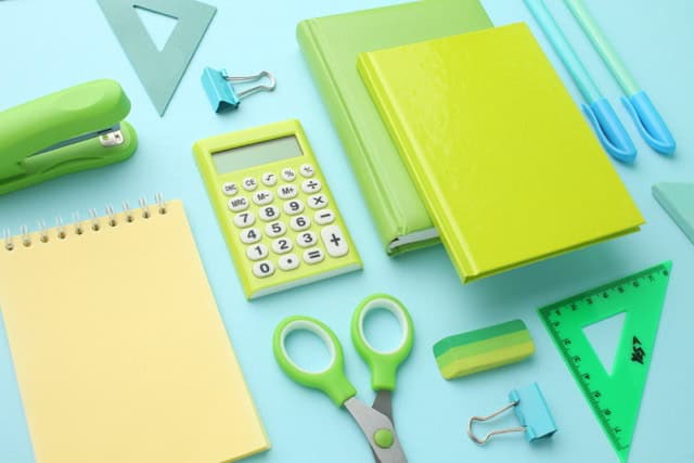 Stationery calculator ruler calculator and school stuff on coloured background.