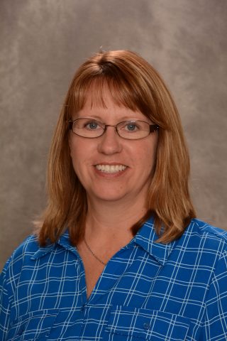 First grade teacher at JFK Catholic School with red hair and glasses.