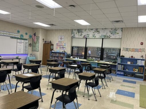 Bright JFK Catholic School classroom with desks and educational materials.
