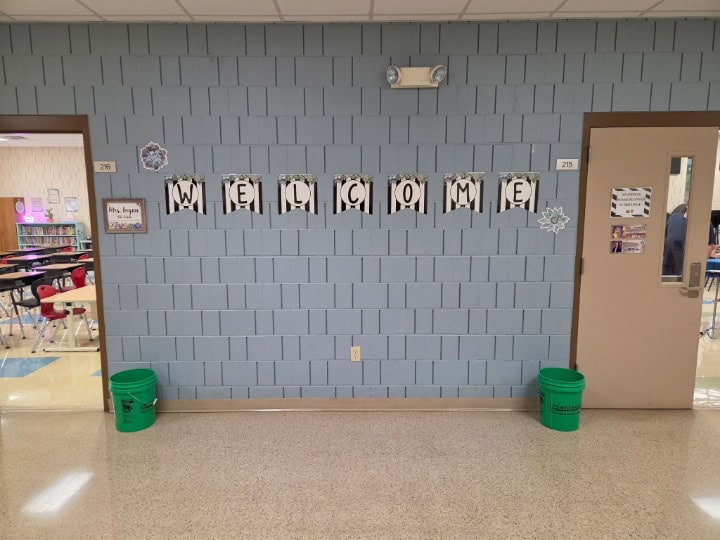 JFK Catholic School welcome sign with 'Welcome' banner and green buckets.